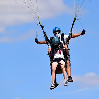 Ein Pilot eines Gleitschirms fliegt zusammen mit einem Kind. - Gleitschirm Tandemflug für Kinder am Ossiachersee