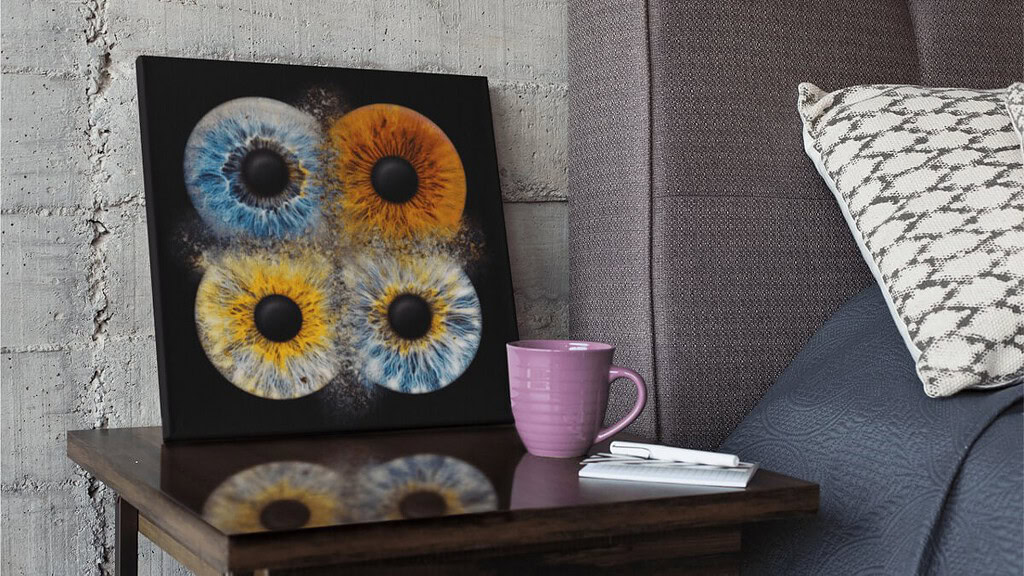 iris_fotoshooting_familie_web-18.jpeg Die 4 miteinander kollidierenden Iriden sind auf einer dunklen Leinwand verewigt worden, das Bild steht an die Wand gelehnt auf dem Nachttisch