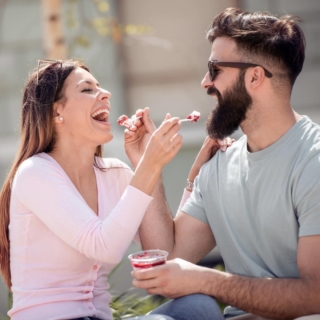 kulinarik-fuer-zwei Ein Pärchen füttert sich gegenseitig mit Dessert und lacht