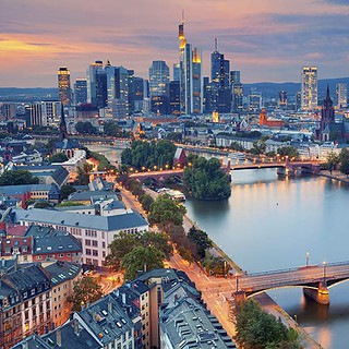 kulinarische-Stadtfuehrung-Frankfurt-1.jpg Luftaufnahme von Frankfurt am Main am Abend, Fluss und Brücke im Vordergrund