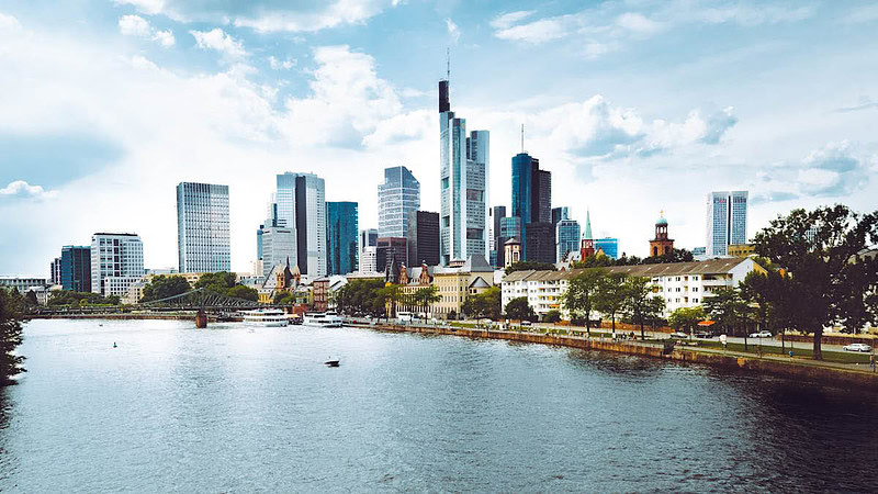 Blick auf Frankfurt am Morgen, mit dem Fluss im Vordergrund und den Wolkenkratzern im Hintergrund