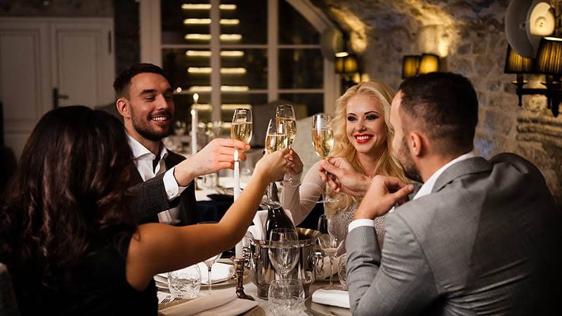 die Gäste im Restaurant reden miteinander und stoßen mit Champagner an