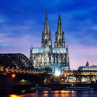 kulinarische-Stadtfuehrung-mit-Raetsel-Koeln-1.jpg Blick auf den Dom und die Stadt Köln bei Nacht