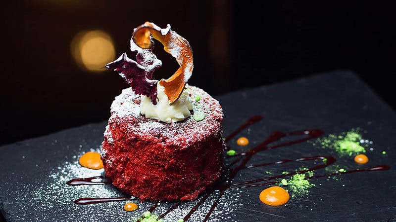 Eine Vorspeise auf einem dunklen Teller mit Soße serviert