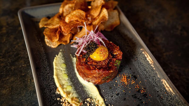 Beefsteak Tatar mit Paste und Gemüse auf einem Teller zubereitet