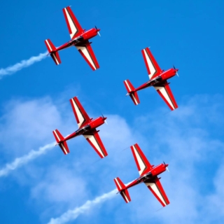 4 kleine Flugzeuge beim Kunstflug in der Luft