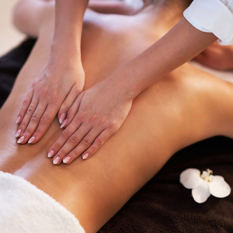 Eine Frau bekommt eine Rückenmassage bei einer Körperbehandlung