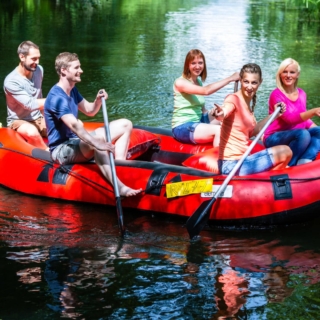 schlauchboot-touren-erlebnisse Eine Gruppe von Freunden fährt mit einem Schlauchboot zusammen