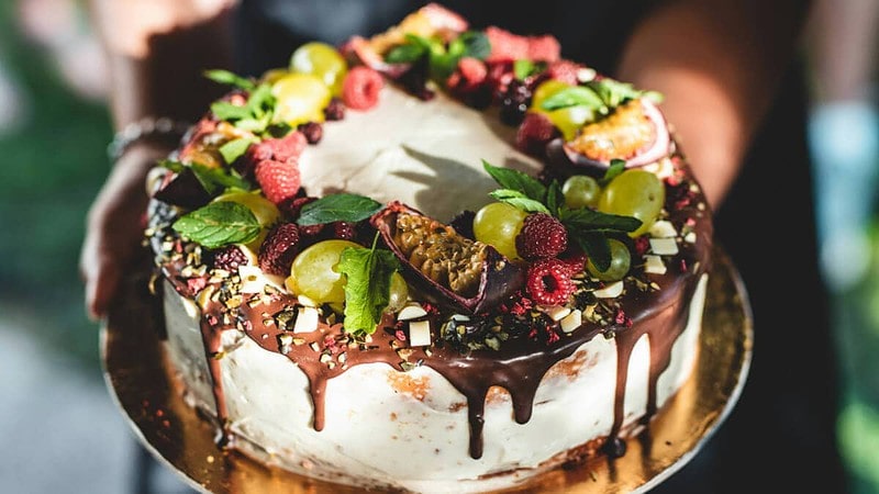 weißer Schokoladenkuchen mit Schokoladensauce und Früchten