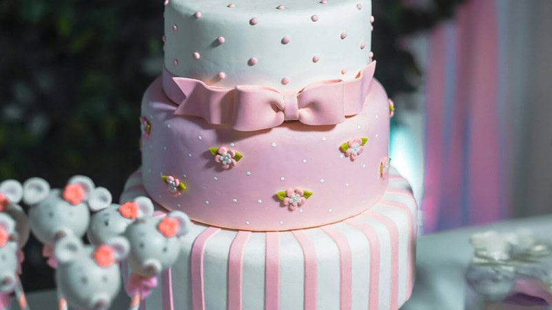 Geburtstagstorte mit essbaren Blumen und Schleifen verziert