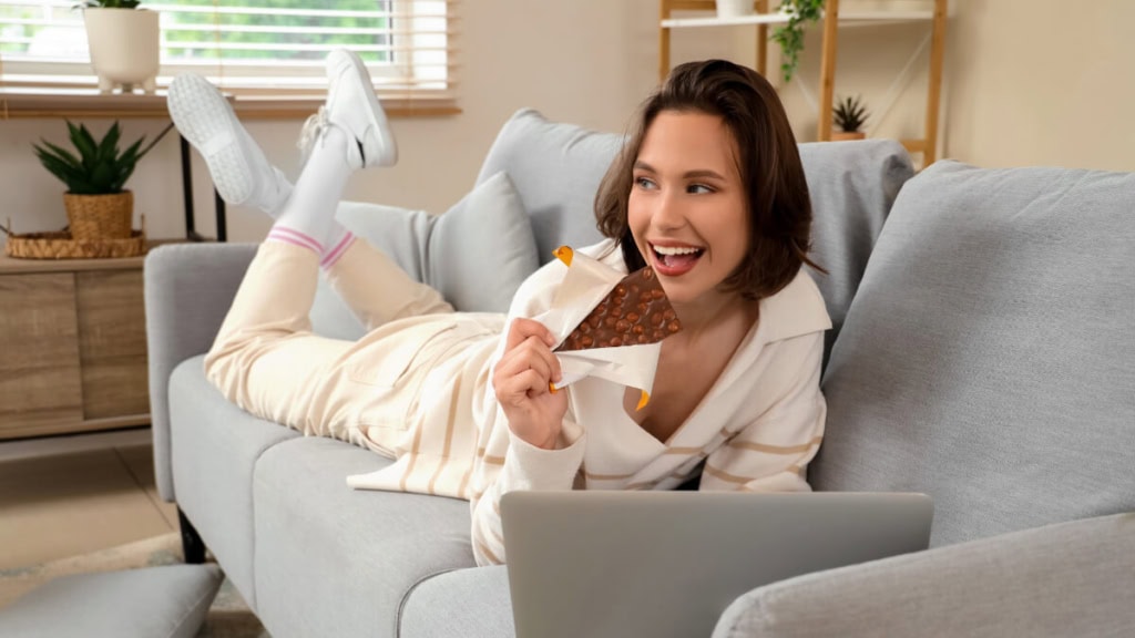 schokoladen-verkostung-online (2) Eine Frau liegt auf der Couch und nimmt an einer Online Schokoladenverkostung teil