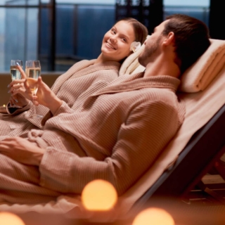 spa-pakete-erlebnisgutscheine Ein Paar genießt die Auszeit im SPA zusammen und trinkt Champagner