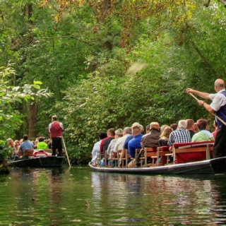 Eine Kahntour wird auf der Spree durchgeführt. Viele Menschen fahren mit dem Kahn.
