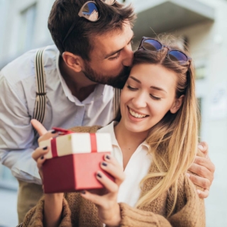 Eine Frau bekommt ein Geschenk von ihrem Mann und lächelt