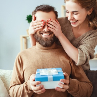Ein Mann bekommt ein Geschenk von seiner Frau und lächelt