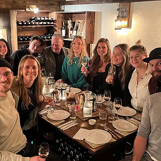 Eine Gruppe die eine Weinverkostung in einem Weinkeller genießt.