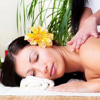 eine Frau wird massiert, der Masseur verwendet Lomi-Lomi-Techniken