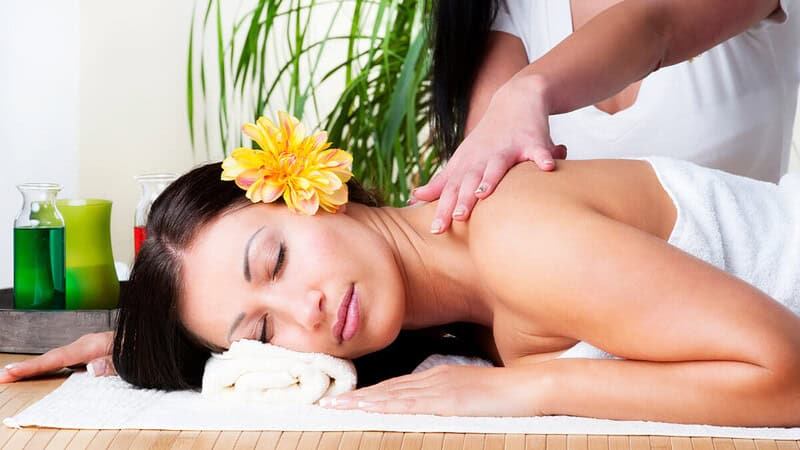 eine Frau wird massiert, der Masseur verwendet Lomi-Lomi-Techniken