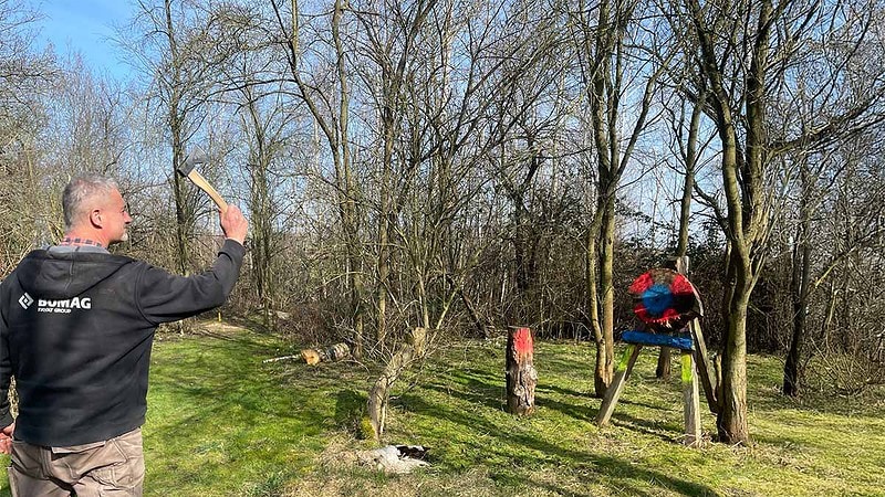 Ein Mann versucht mit einer Wurfaxt ein Ziel zu treffen.