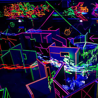 Lasertag Düsseldorf Spielfeld Ein Labyrinth aus Neon leuchtenden Wänden aus der Vogel Perspektive.