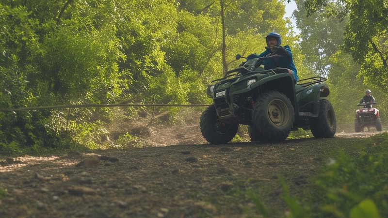 Zwei Quadfahrer im Wald auf einem Schotterweg