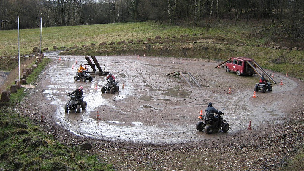 Quadtour-Kassel-Fahrer auf Parkur im Matsch 5 Quadfahrer auf einem Parkour im Matsch
