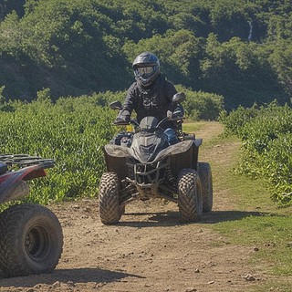 Quadtour-Rheine-Fahrt um die Kurve Zwei Fahrer fahren um die Kurve auf einem Feldweg