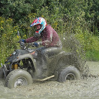 Quadtour-Schwerin-Matschfahrt Eine Frau fährt durch Schlammiges Wasser mit Vollgas