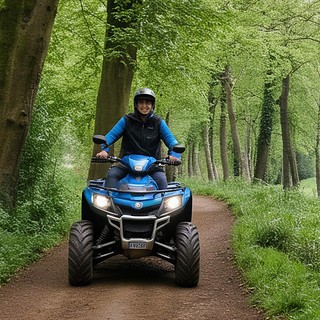 Quadtour-Trier-Fahrer auf Waldweg Ein Quadfahrer mit blauem Quad auf Waldweg
