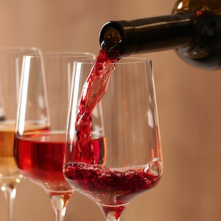 Weingläser stehen hinterinander und es wird Wein eingeschenkt