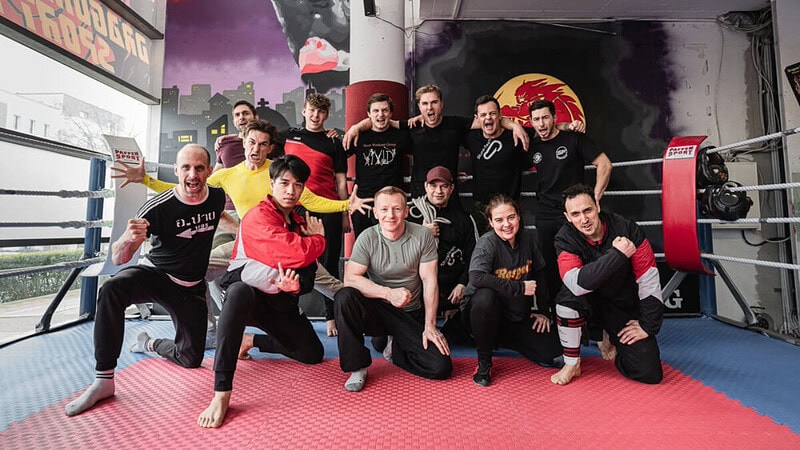 Gruppenfoto von einem Kampfteam auf roter Sportmatte