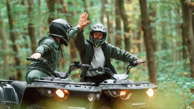2 Quad Fahrer die sich einen High Five geben.