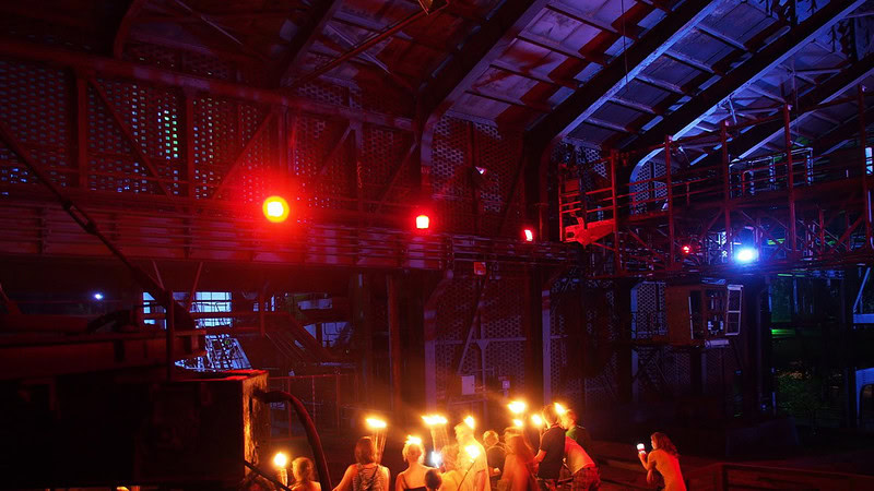 Halle mit bunten Lichtern und einer Gruppe von Menschen mit Lampen