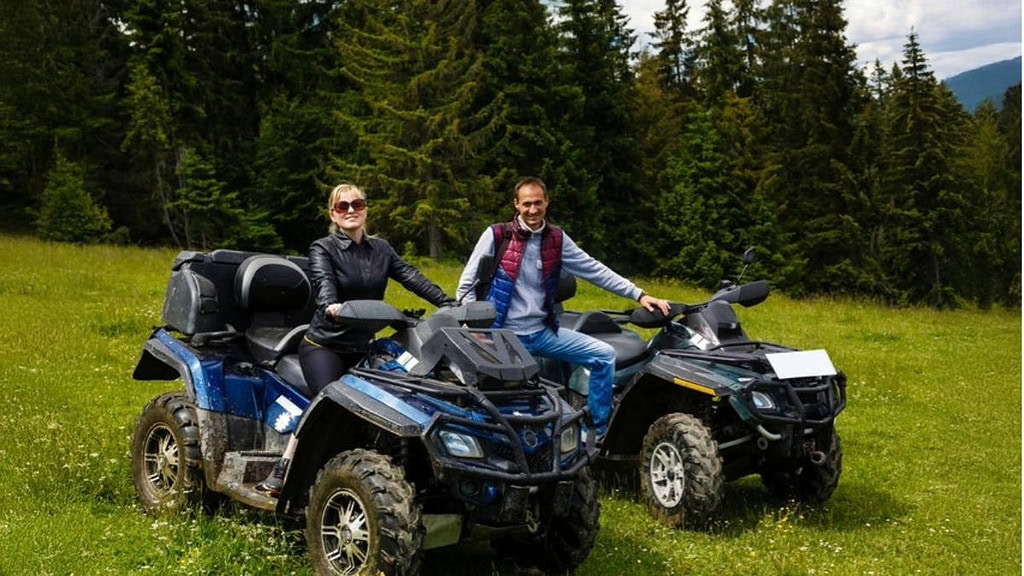 Paar mit Quads auf Wiese Ein Paar das mit ihren Quads auf einer Wiese steht und in die Kamera lacht.