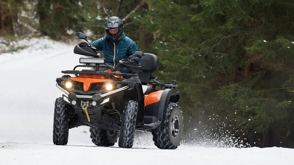 Quad driftet auf Schnee Ein Quad Fahrer der auf Schnee Driftet.