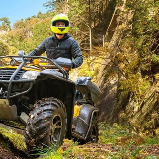 Quad fährt über hügel Ein Quad Fahrer der in einem Tal über einen Hügel fährt.