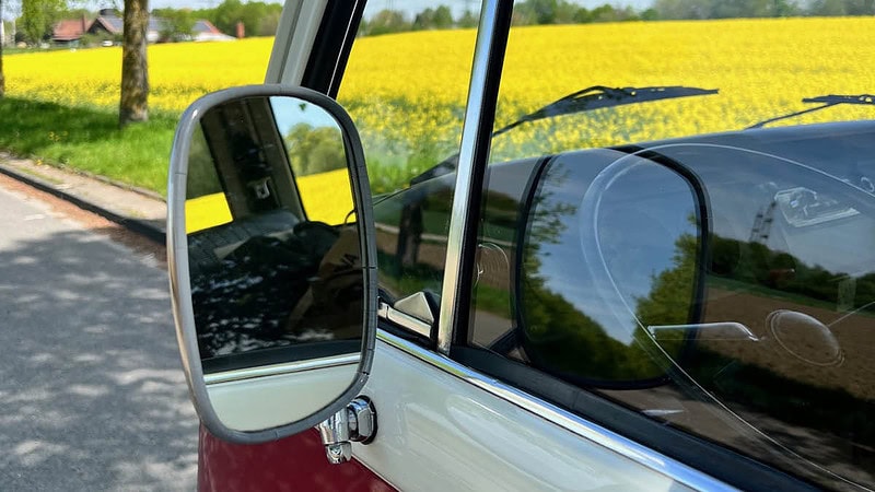 VW Bulli Rückspiegel auf Landstraße mit Rapsfeld