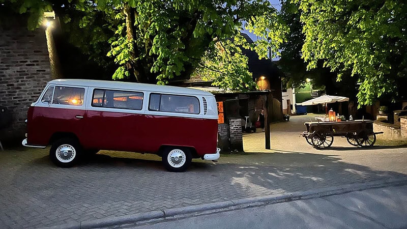 roter VW Bulli der auf dem Fußweg parkt
