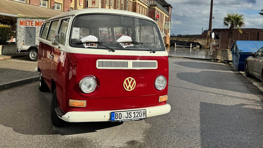 Deine Zeitreise- Bulli steht auf der Straße VW Bulli mit Flyern unter den scheiben der auf einer Straße Parkt.