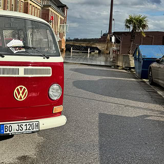 VW Bulli mit Flyern unter den scheiben der auf einer Straße Parkt.