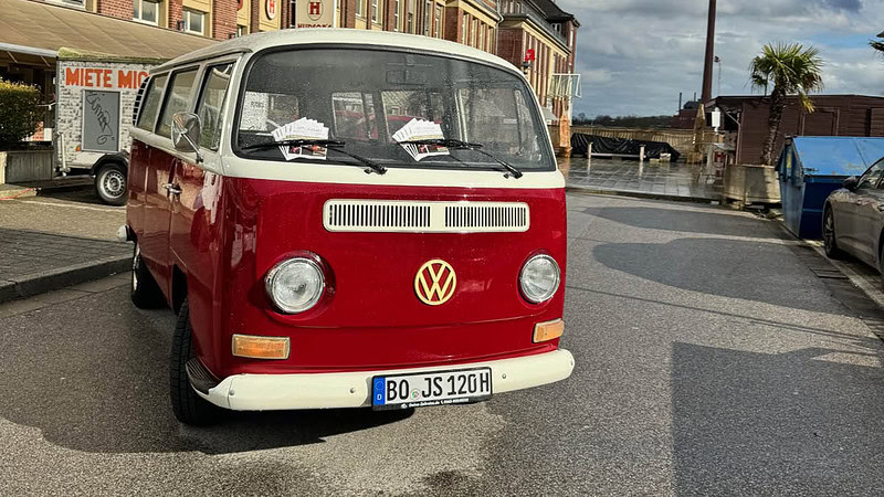 VW Bulli mit Flyern unter den scheiben der auf einer Straße Parkt.