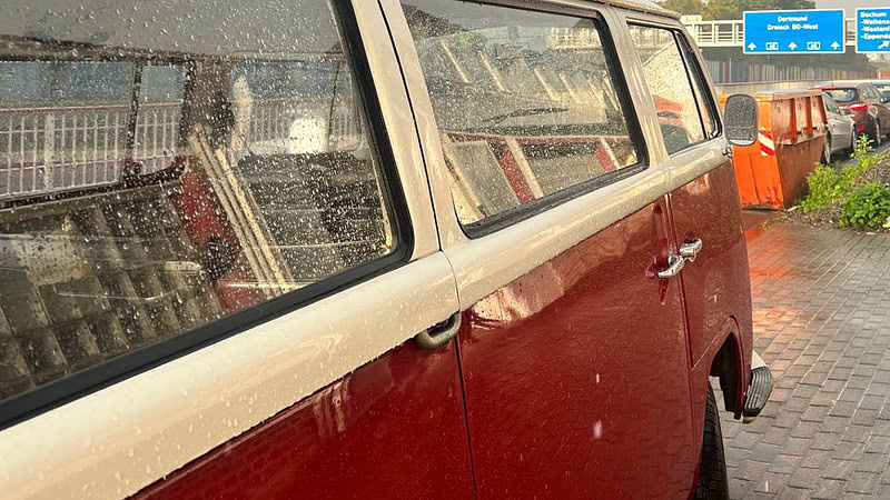 Nasser roter VW Bulli von der Seite