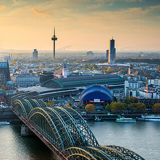 Vogelperspektive auf den Kölner Dom und die Kölner Innenstadt bei Dämmerung.