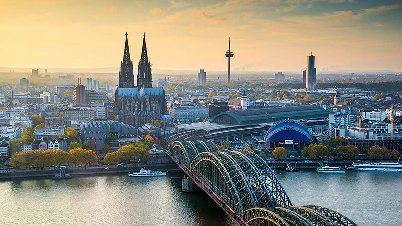 Vogelperspektive auf den Kölner Dom und die Kölner Innenstadt bei Dämmerung.