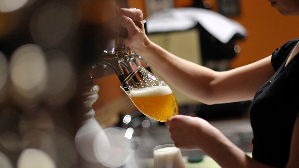 frau-zapft-bier Ein Frau zapft Bier in einer Bar