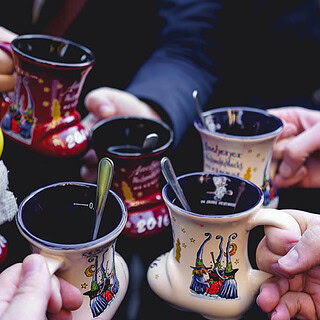 eine Gruppe Leute stößt mit Glühwein an