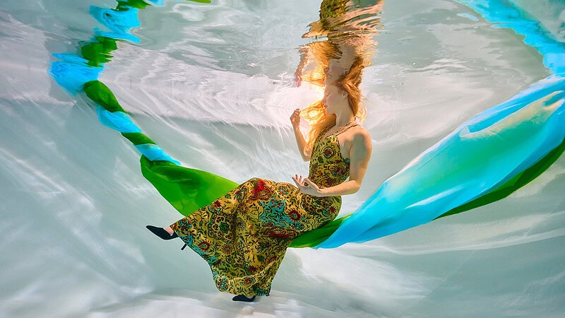 Eine Frau posiert sitzend beim Unterwasser Fotoshooting.