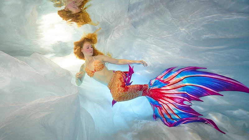 Eine Frau verkleidet als Meerjungfrau beim Unterwasser Fotoshooting.