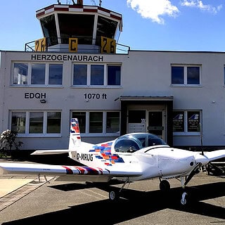 ein Pioneer 200 Flugzeug steht vor dem Tower am Flughafen