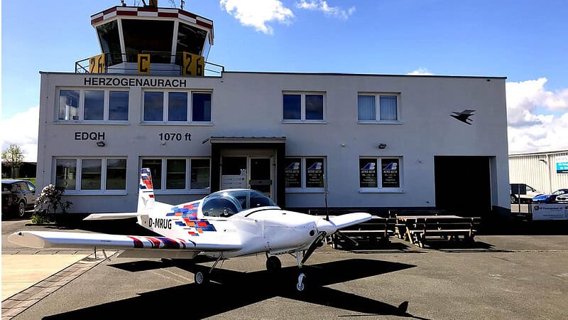 ein Pioneer 200 Flugzeug steht vor dem Tower am Flughafen